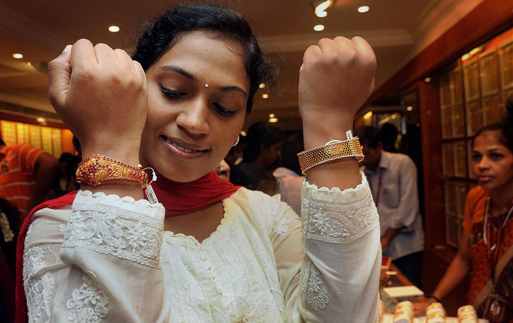 A woman buys gold bangles at a jewellery shop in Chennai on the occasion of Akshaya Tritiya.