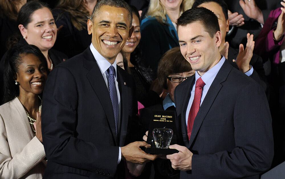 President Obama presents the 2014 National Teacher of the Year Sean McComb, a high school English teacher from Maryland who helps push students toward college, with his award during a ceremony to honor the 2014 National Teacher of the Year and finalists in the East Room of the White House in Washington.