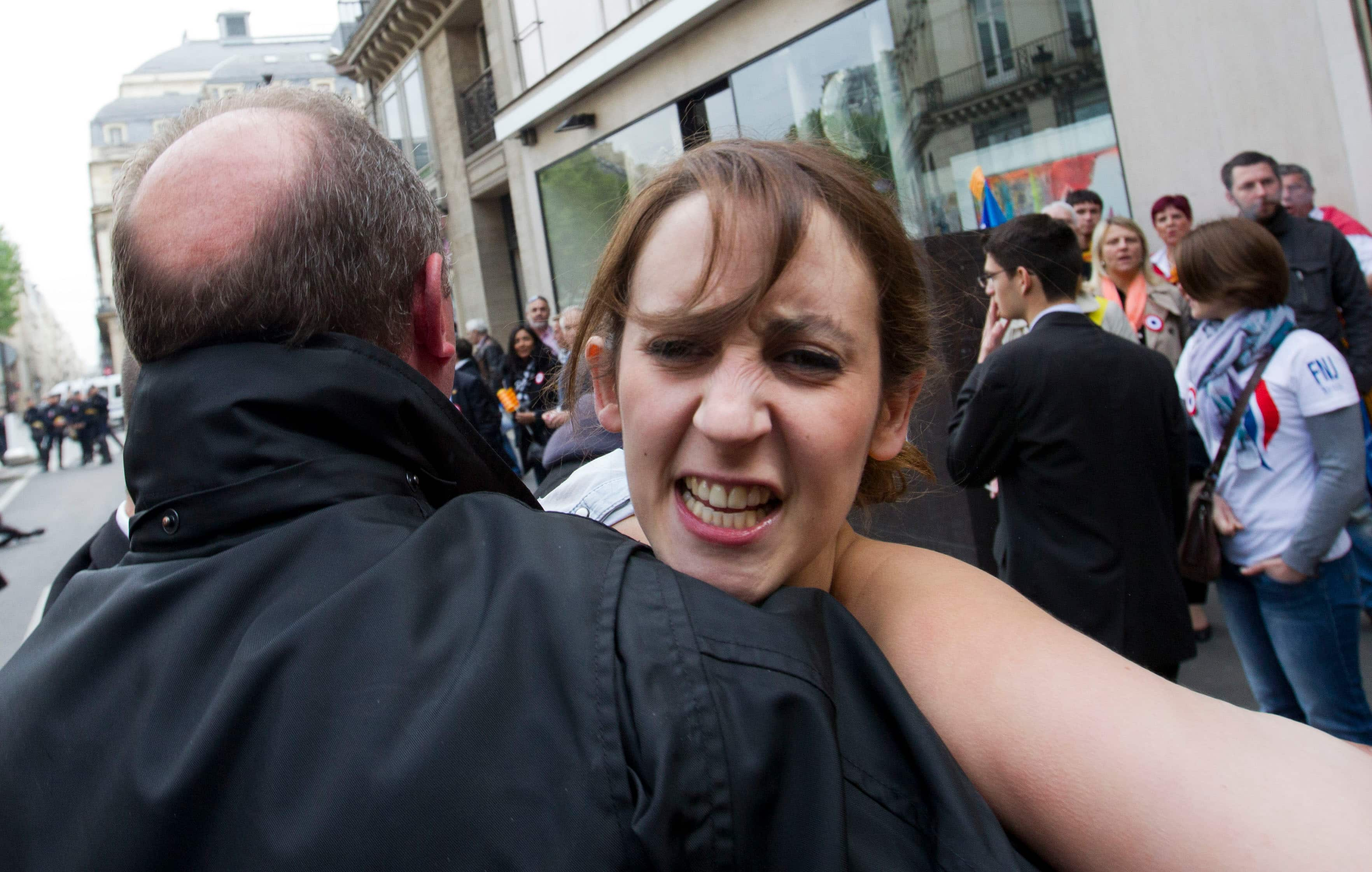 A Femen activist is carried away by police during the French far-right party`s annual march in Paris.