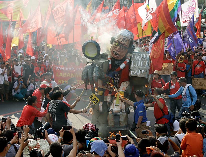 Workers from the militant labor organization Kliusang Mayo Uno (May 1st Movement) burn an effigy of Philippine President Benigno Aquino III to mark Labor Day celebrations, near the Presidential Palace in Manila.