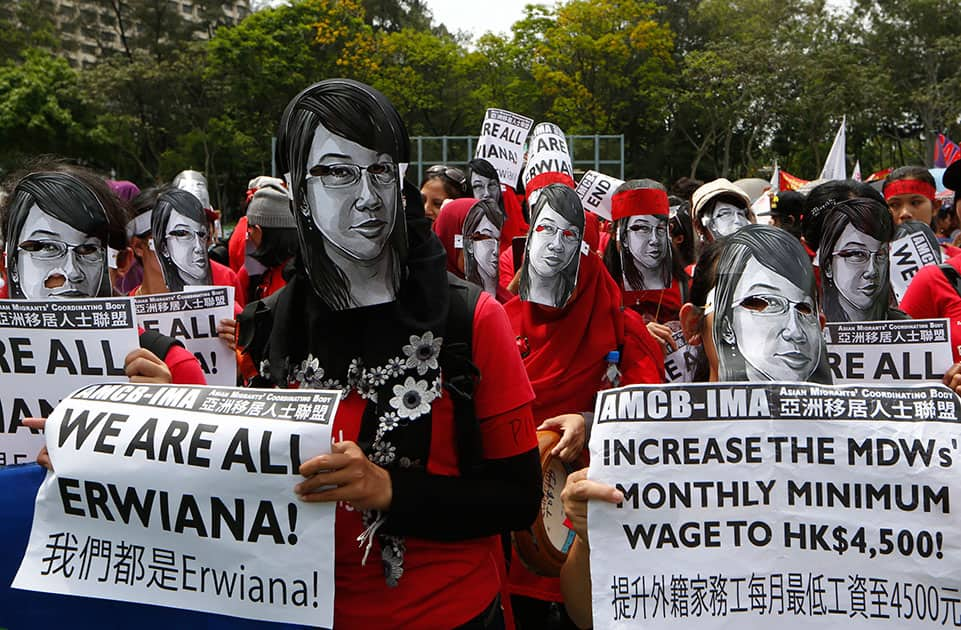 Domestic helpers and their supporters wear masks featuring the picture of Indonesian maid Erwiana Sulistyaningsih, who was allegedly brutally tortured by her employers, during a march to mark the May Day in Hong Kong.