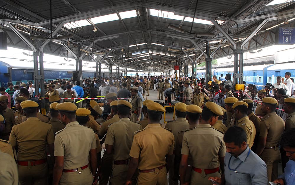 Policemen stand guard next to a passenger train that was ripped by two blasts at the railway station in Chennai. Twin blasts ripped through two coaches of the train Thursday morning just minutes after it pulled into Chennai railway station, one of India`s busiest train stations, killing a 22-year-old woman and injuring 14 people, officials said.