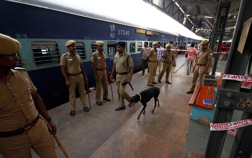 Policemen stand guard next to a passenger train that was ripped by two blasts at the railway station in Chennai. Twin blasts ripped through two coaches of the train Thursday morning just minutes after it pulled into Chennai railway station, one of India`s busiest train stations, killing a 22-year-old woman and injuring 14 people, officials said.