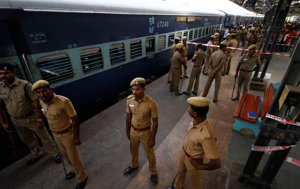 Policemen stand guard next to a passenger train that was ripped by two blasts at the railway station in Chennai. Twin blasts ripped through two coaches of the train Thursday morning just minutes after it pulled into Chennai railway station, one of India`s busiest train stations, killing a 22-year-old woman and injuring 14 people, officials said.