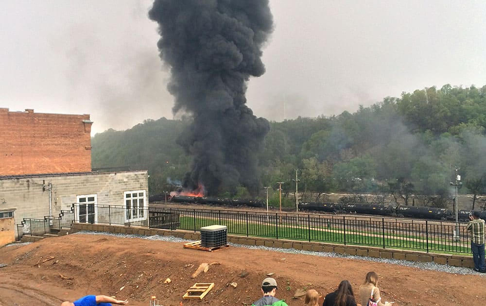 In this mobile phone photo provided Charles Peters, smoke rises after several CSX tanker cars carrying crude oil derailed, in Lynchburg, Va. Authorities evacuated numerous buildings Wednesday after the derailment. 