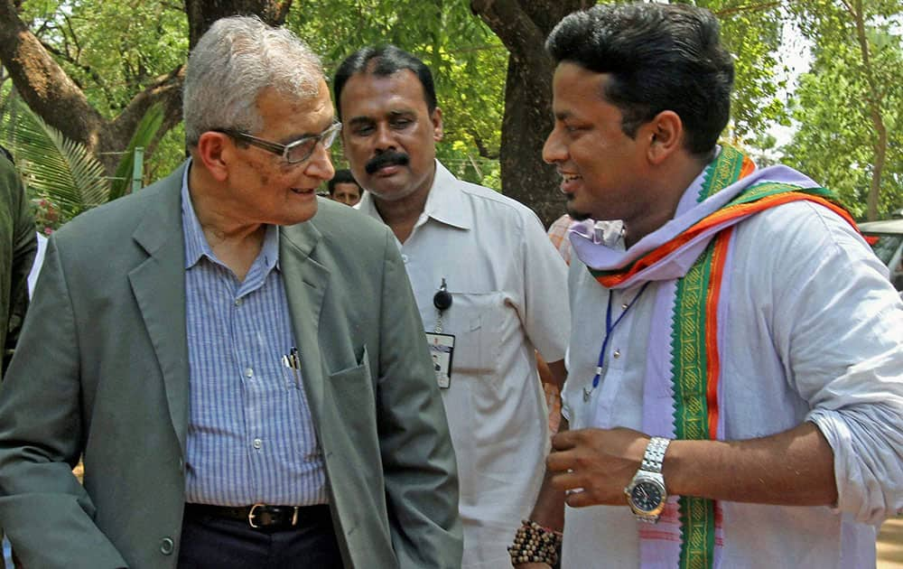 Nobel laureate Amartya Sen talking with TMC candidate Anupam Hazra (R) on the way to a polling booth to cast his vote at Santiniketan in Birbhum district of West Bengal.