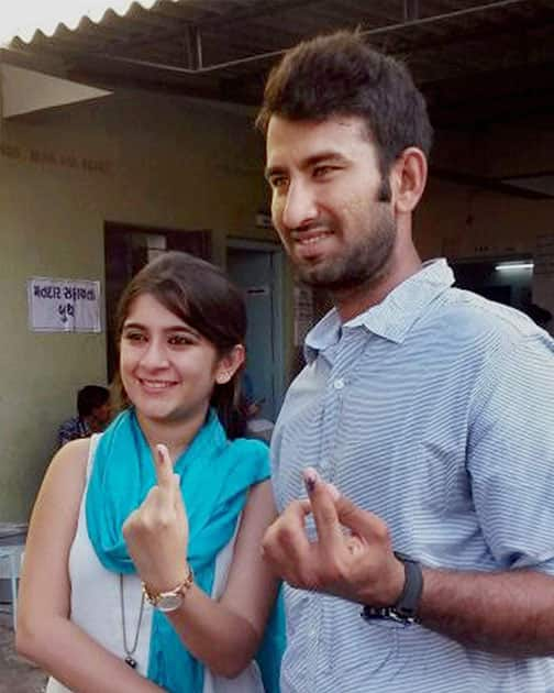 Cricketer Cheteshwer Pujara and his wife Puja display their inked fingers after casting votes for Lok Sabha elections in Rajkot.