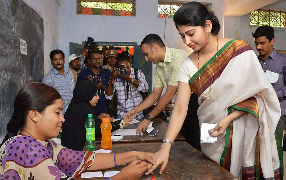 An IAS officer gets her finger marked before casting her vote at a polling station in Medak.