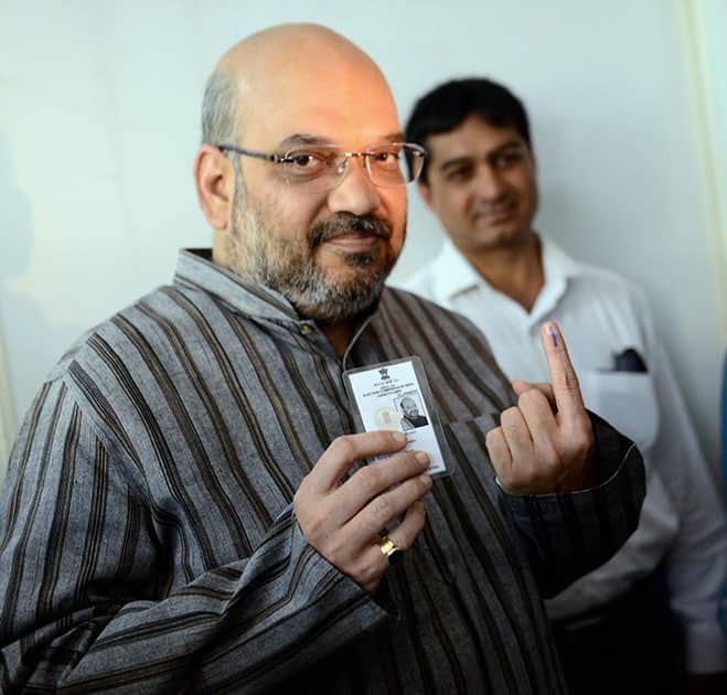 BJP leader Amit Shah shows his inked finger after casting his vote for Lok Sabha polls at a polling station in Ahmedabad.