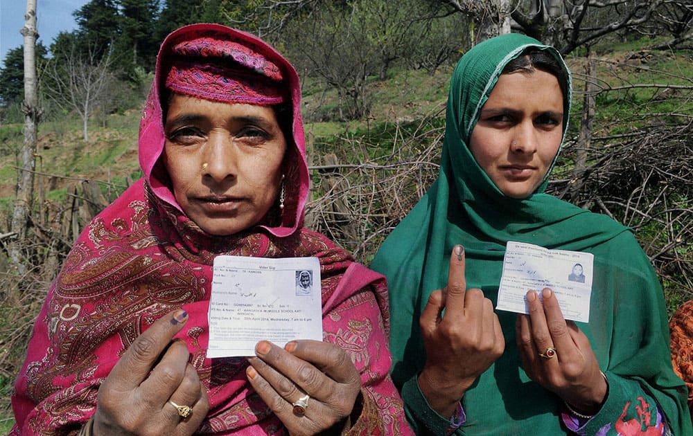 Women show their inked fingers after casting votes for Lok Sabha elections, at a polling station in Ganderbal.