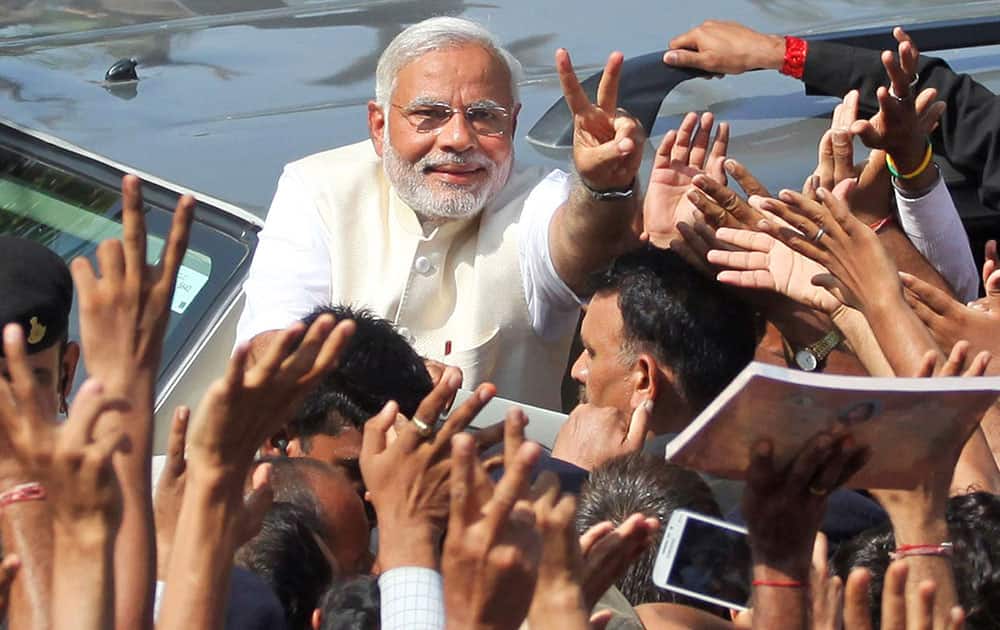 India`s main opposition Bharatiya Janata Party’s prime ministerial candidate Narendra Modi displays the victory symbol to supporters after casting his vote in Ahmedabad.
