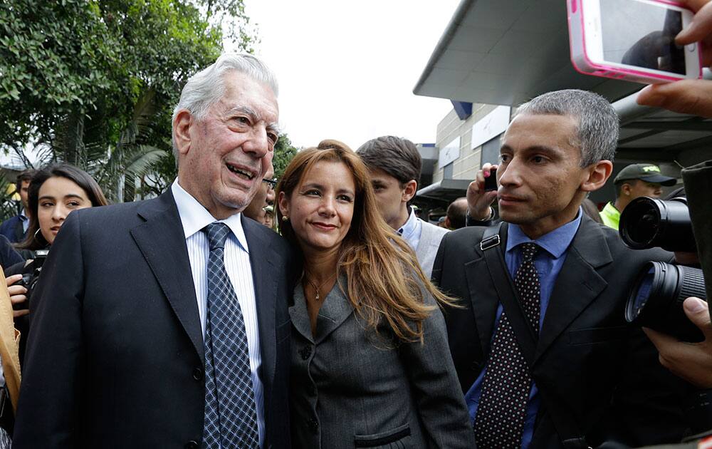 Peruvian novelist and Nobel literature laureate Mario Vargas Llosa, center, left, poses for a photo with a fan at the International Book Fair in Bogota, Colombia. Peru is the guest of honor at the capital`s annual fair.