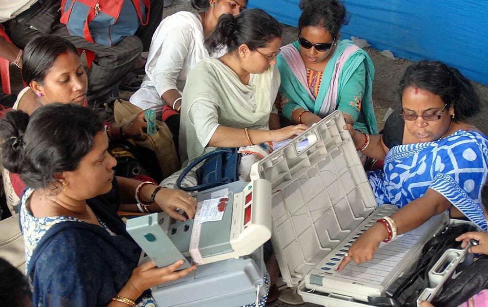 Women polling officials checking the EVMs at voting materials distribution centre on the eve of 7th Lok Sabha elections at Chunchura in Hooghly district of West Bengal.