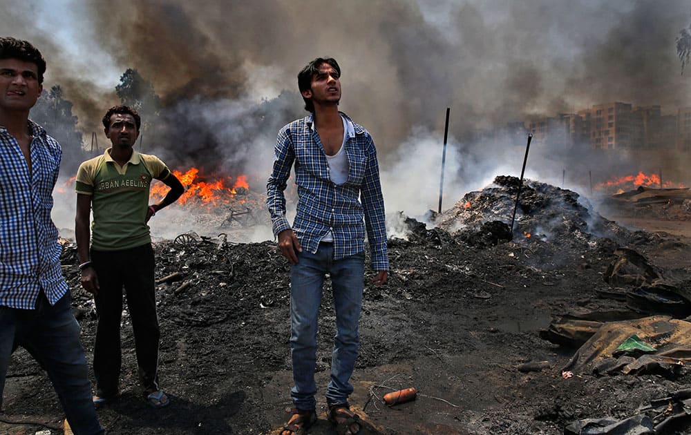 People watch a fire at a warehouse storing leftover cloth strips in New Delhi.