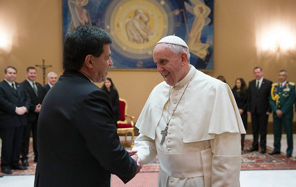 Pope Francis shakes hands with Paraguay`s President Horacio Cartes during a private audience at the Vatican.