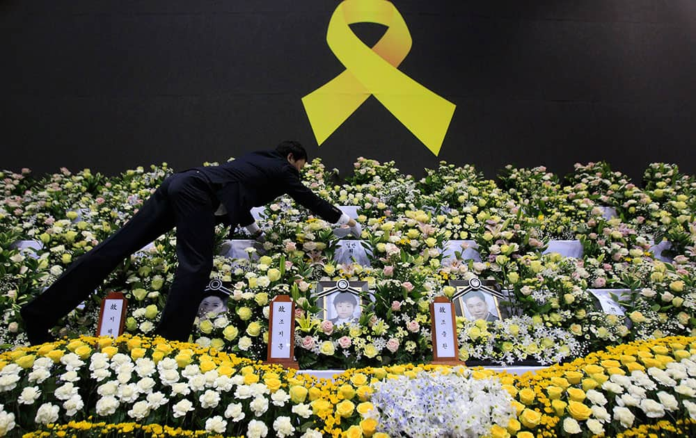 A funeral service employee sets up a group memorial altar for victims of the sunken ferry Sewol in Ansan, south of Seoul, South Korea.