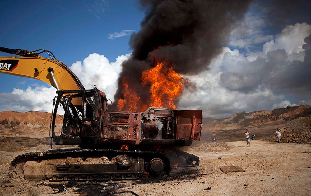 A backhoe used for illegal mining burns after being destroyed by authorites in Huepetuhe district in Peru`s Madre de Dios region in Peru.