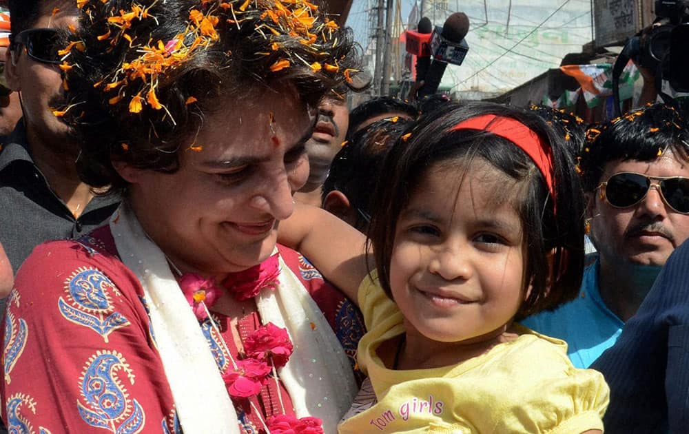 Priyanka Vadra holds a girl during an election campaign for her mother and Congress President Sonia Gandhi in Raebareli.