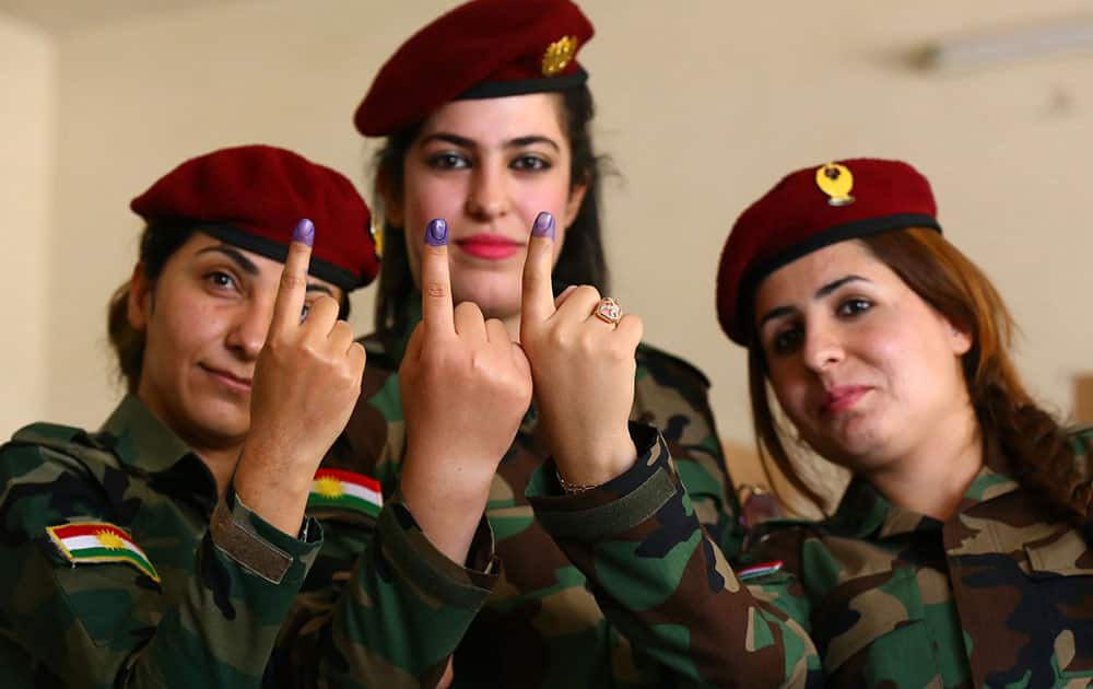 Kurdish police women show inked fingers after casting votes at a polling center in Irbil, 217 miles (350 kilometers) north of Baghdad, Iraq.