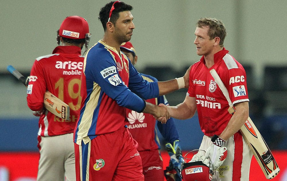 George Bailey of the Kings X1 Punjab and Yuvraj Singh of the Royal Challengers Bangalore shake after the match in Dubai.