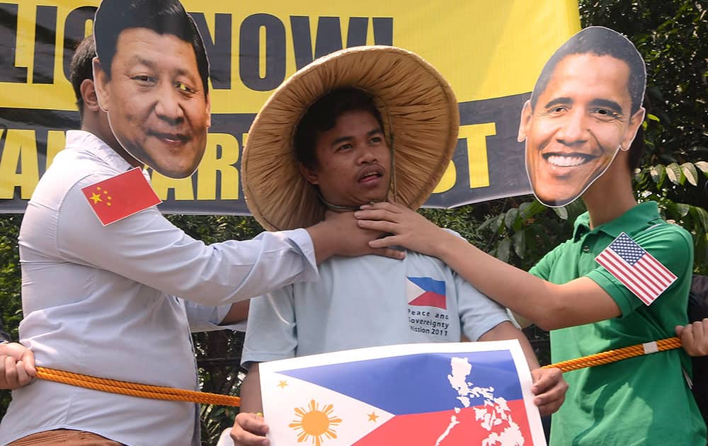 A group of Filipino protesters stage a protest to oppose the visit of US President Barack Obama as they perform a tug of war between Chinese President Xi Jinping and US President Obama with the Philippine flag in Quezon City, Philippines.