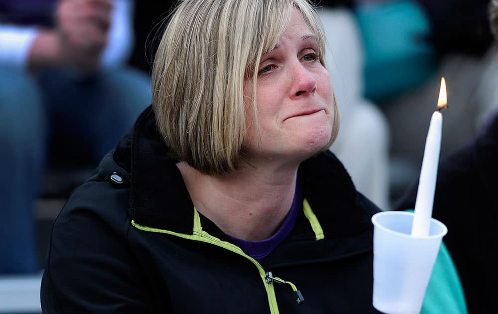 A woman cries during a vigil for Maren Sanchez at Jonathan Law High School, in Milford, Conn. Sanchez was fatally stabbed inside the school on Friday hours before her junior prom.