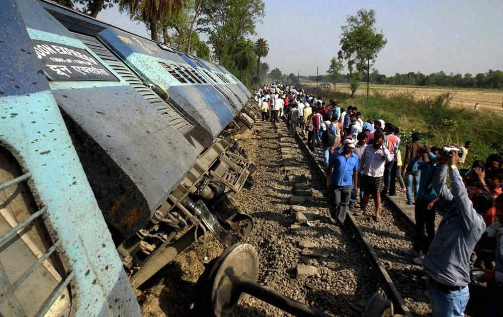 People look at the coaches of Doon Express that derailed at Jaffarganj near Ambedkar Nagar.