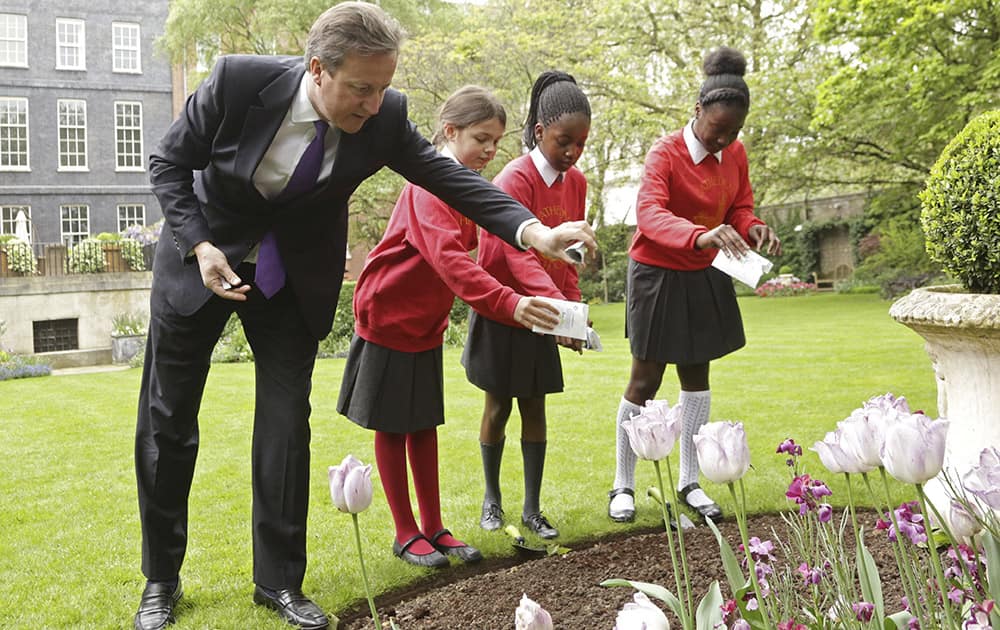 British Prime Minster David Cameron sows poppy seeds with pupils from Cathedral Primary School in Soutwark, in the gardens of Downing Street in London, to help launch the (RBL) Royal British Legion`s poppy campaign.