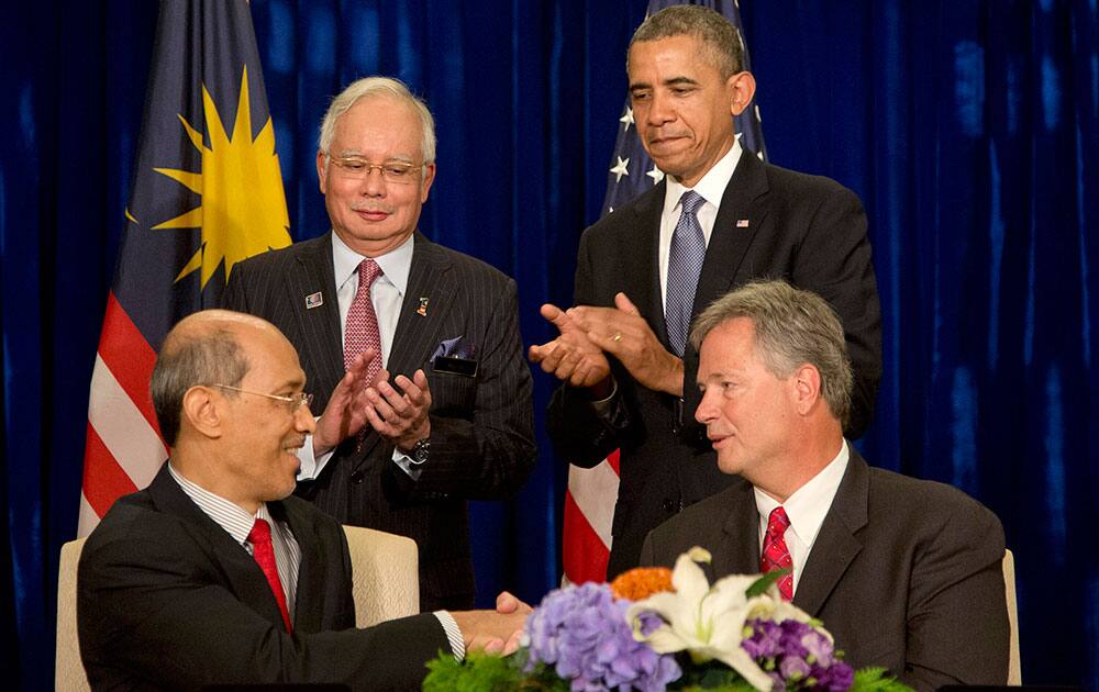 President Barack Obama, standing right, and Malaysian Prime Minister Najib Razak, standing left, applaud as Bill Radany, president & CEO of Verdezyne, right, and Tan Sri Dato` Seri Mohd Bakke Salleh, President & Group Chief Executive of Sime Darby Berhad, left, participate in the signing of major commercial agreements with American businesses at the Ritz-Carlton in Kuala Lumpur, Malaysia.