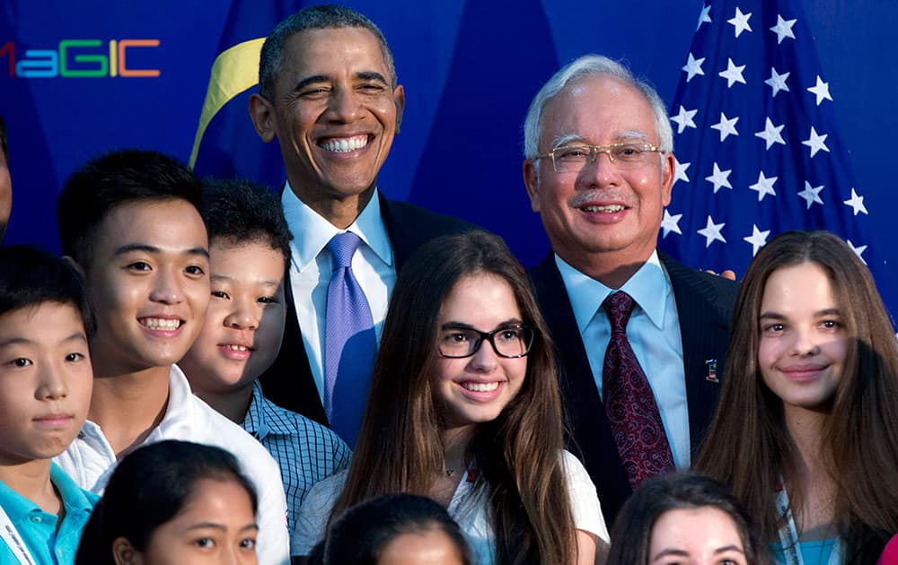 President Barack Obama, rear center left, and Malaysian Prime Minister Najib Razak, rear center right, pose for photographs with young student as they visits the Malaysian Global Innovation and Creativity Centre in Cyberjaya, Malaysia.