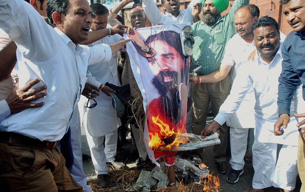 Members of Valmiki Samaj and Congress workers burning the effigy of Baba Ramdev during a protest over his remarks on Rahul Gandhi in Patiala.