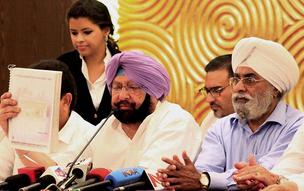 Congress candidate Capt. Amarinder Singh and Prime Minister Manmohan Singh`s brother Surjit Singh Singh Kohli addresses a press conference in Amritsar.