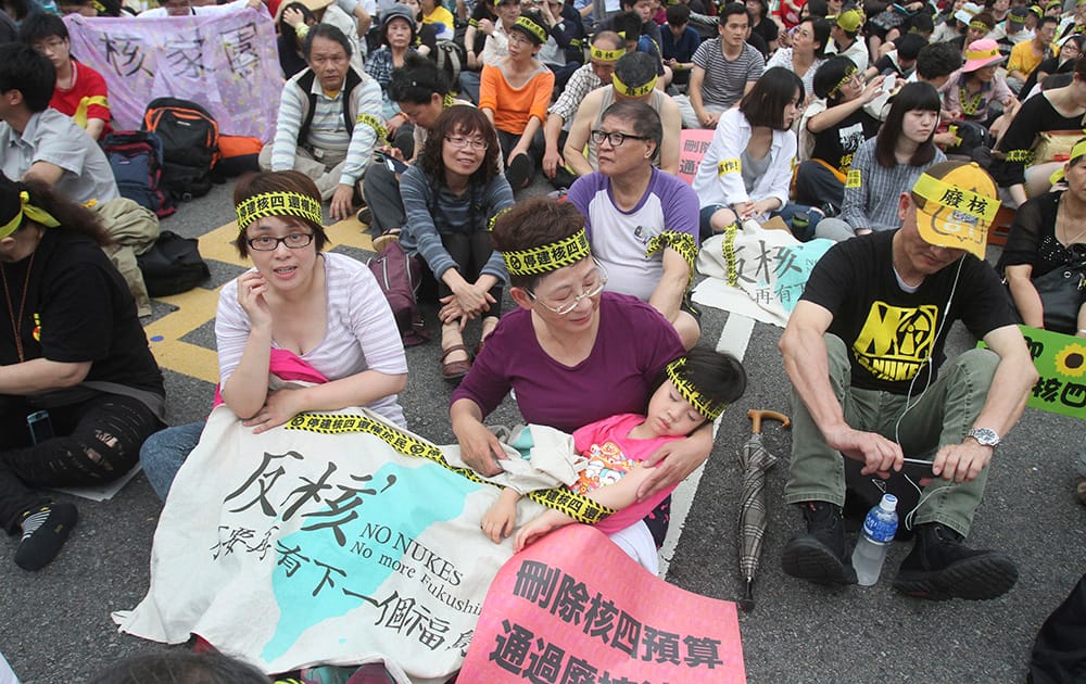 Taiwanese people stage a sit-in protest against the planned construction on the fourth nuclear power plant to be completed on the 28th memorial day of Chernobyl nuclear disaster, in Taipei.