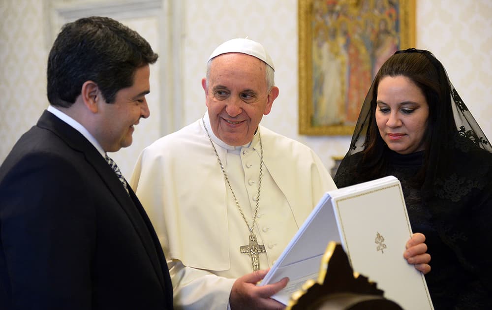 Honduras President Juan Orlando Hernandez, left, and Pope Francis exchange gifts on the occasion of their private audience at the Vatican.