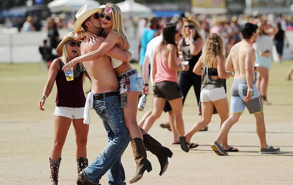 Stagecoach festival goers Nick Powaser and Amanda Hoj greet each other on the Empire Polo Field on day one of the 2014 Stagecoach Music Festival.