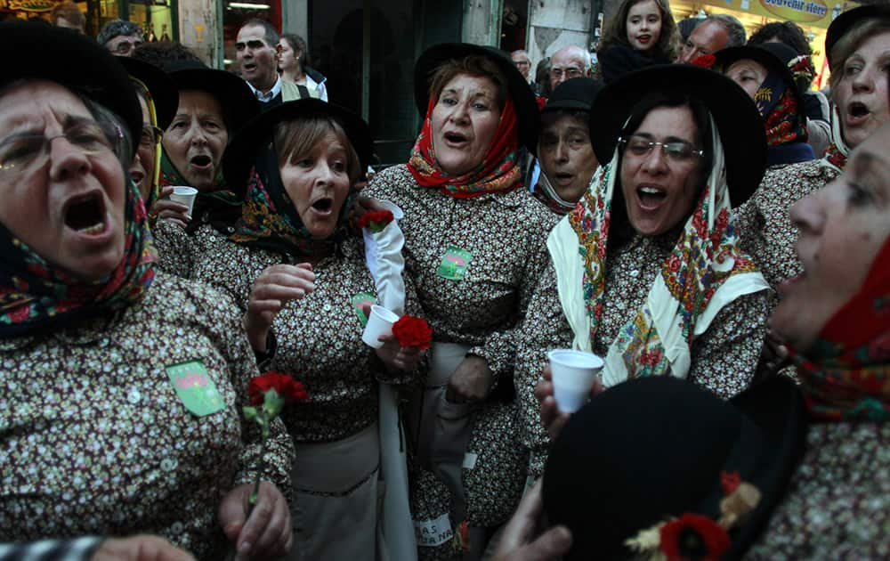 Women dressed in traditional Portuguese clothes sing a song about emigration after a march that celebrated the 40th anniversary of the 25th April revolution that restore the democracy in Portugal in 1974, in Lisbon.