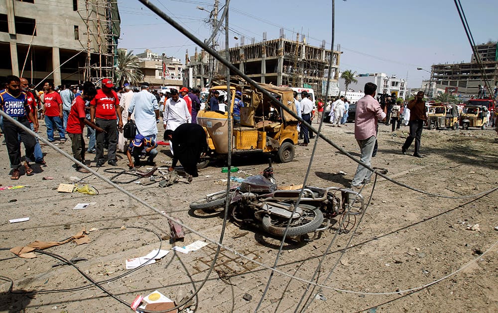 Pakistani officials collect evidence at the site of an explosion in Karachi, Pakistan.