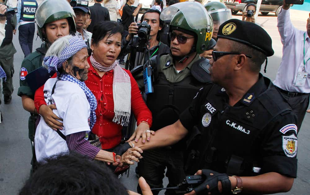 Villagers from Boeung Kak Lake community are stopped by local security guards near a blocked main street near the Phnom Penh Municipality Court during villagers` gathering to call for the release of anti-governments protesters who were arrested in a police crackdown, in Phnom Penh, Cambodia.