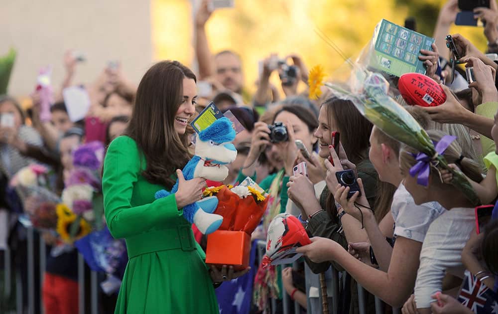 Britain`s Kate, the Duchess of Cambridge, left, meets well-wishers during a visit to the National Portrait Gallery in Canberra.