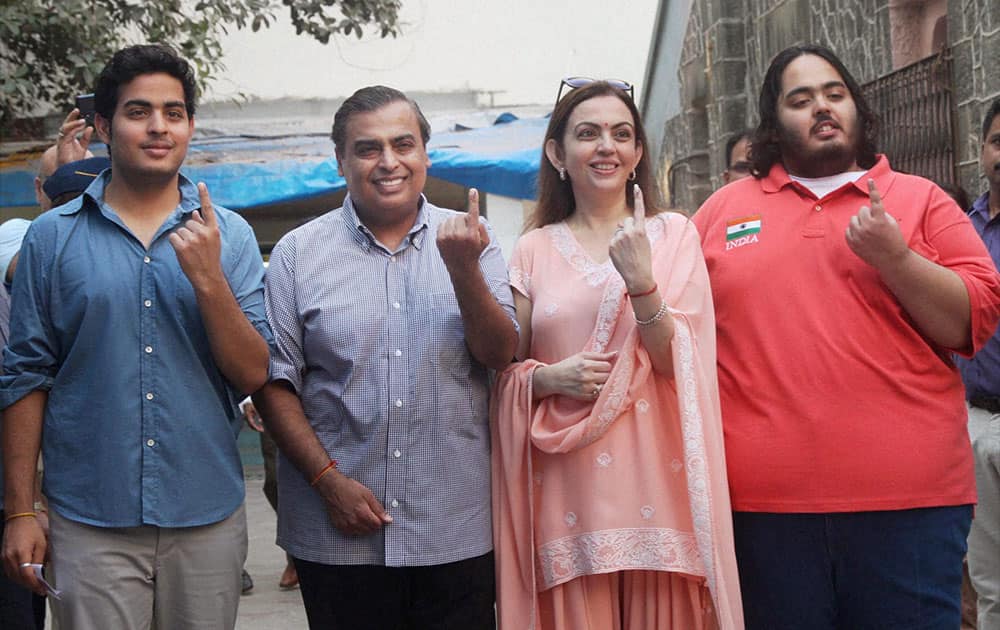 Industrialist Mukesh Ambani with wife Nita Ambani and sons showing ink marked fingers after casting votes for the Lok Sabha elections, in Mumbai.