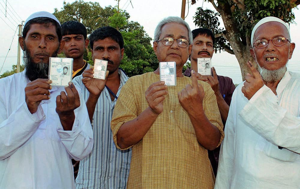 Voters show their ID cards after casting their vote at a polling station in South Dinajpur district of West Bengal.