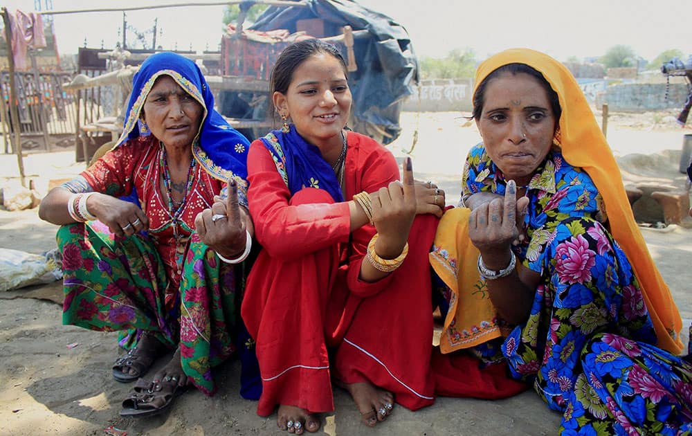 Homeless women voters show their inked fingers after casting votes for Lok Sabha elections at a village in Dausa district of Rajasthan.