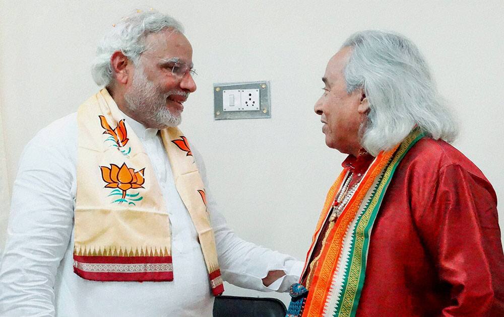 BJP Prime Ministerial candidate Narendra Modi talks to classical vocalist Channulal Mishra after filing his nomination papers in Varanasi.