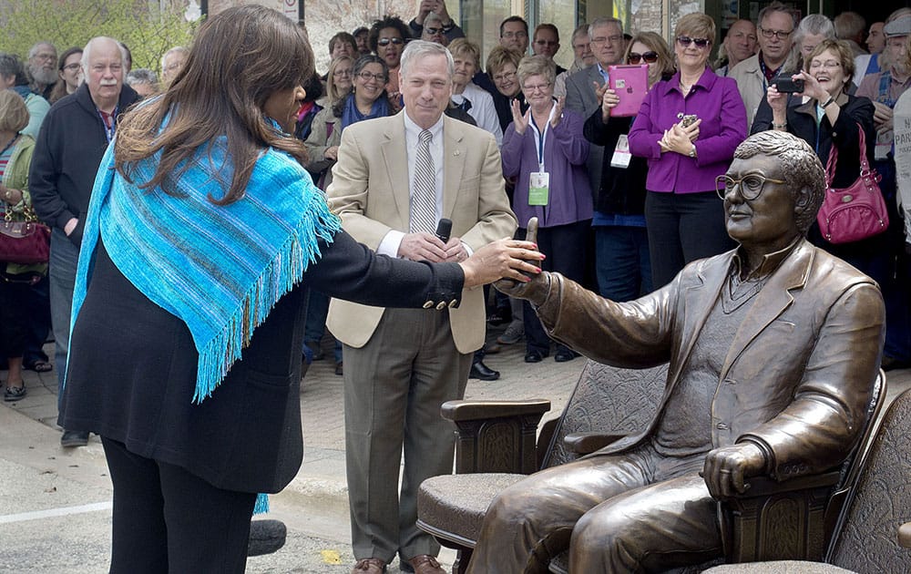 Chaz Ebert touches a statue of her late husband Roger during an unveiling ceremony in front of the Virginia Theater in Champaign, Ill.