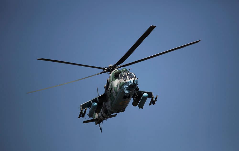 A Ukrainian helicopter flies over a column of Ukrainian Army armored vehicles near Slovyansk, Ukraine.