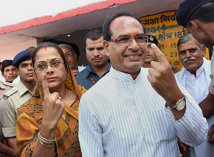 Madhya Pradesh Chief MInister Shivraj Singh Chouhan with his wife Sadhna Singh show their inked fingers after casting votes at a polling booth at his native village Jait, Vidisha in Madhya Pradesh.