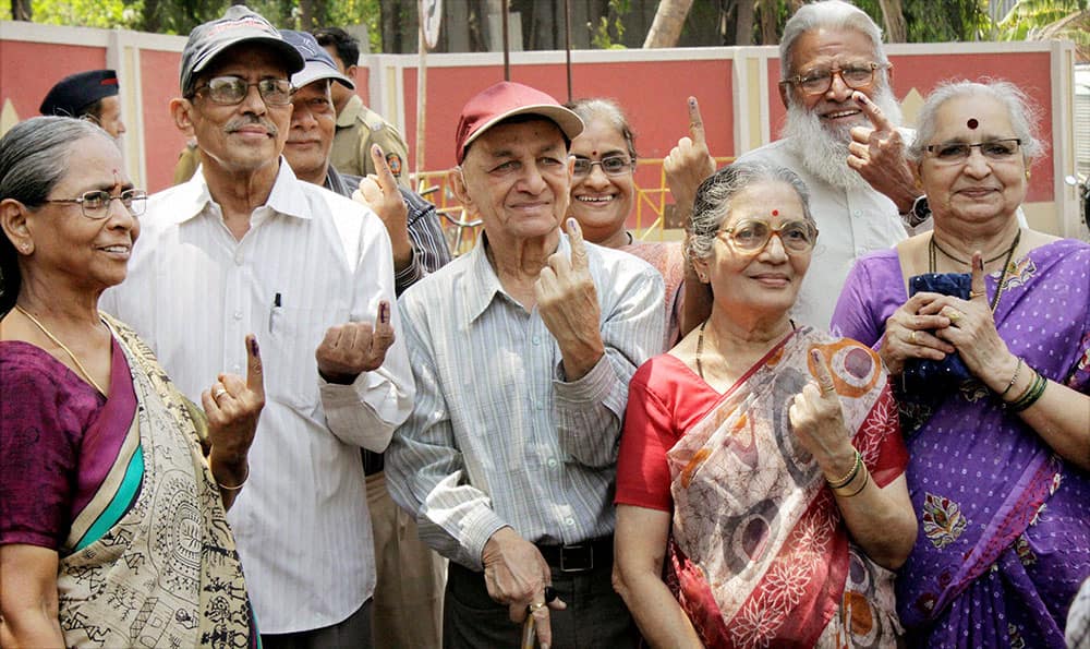 Senior citizens show their inked fingers after casting votes for Lok Sabha polls at a polling booth in Mumbai .