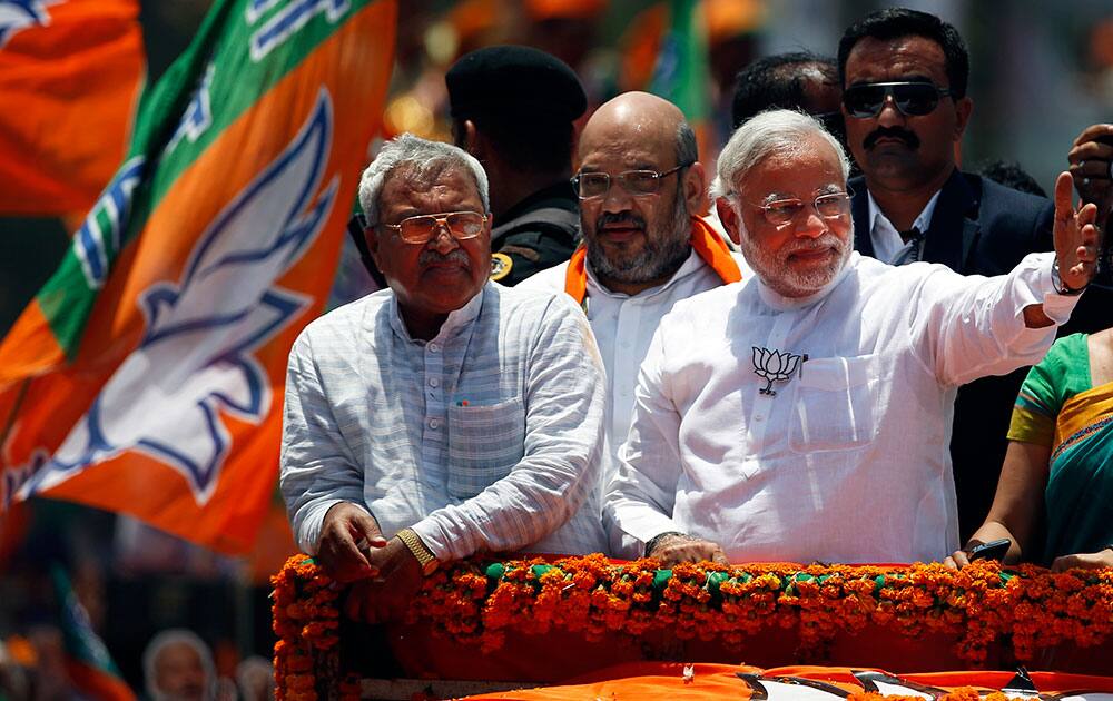 Bharatiya Janata Party’s prime ministerial candidate Narendra Modi greets supporters as he moves on a vehicle to submit his nomination papers in Varanasi, at Varanasi.