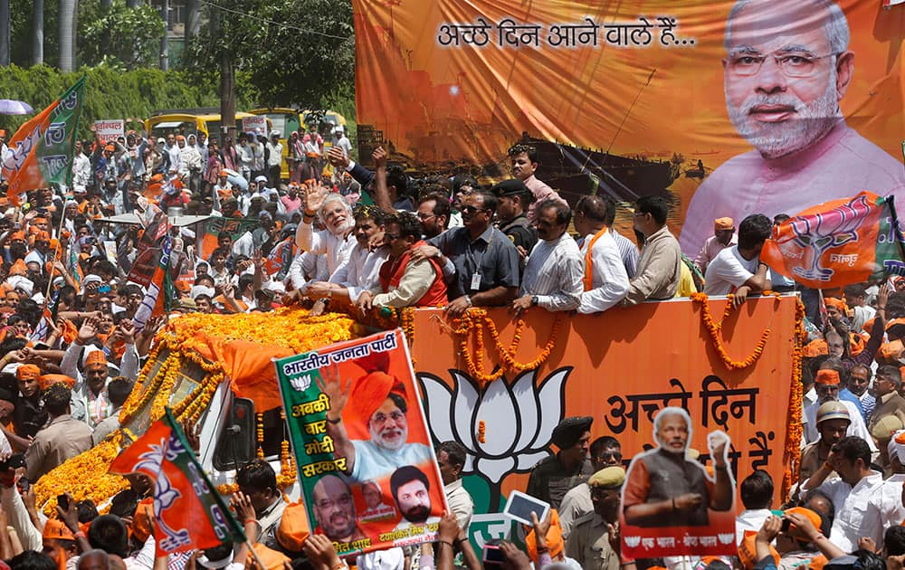 Bharatiya Janata Party’s prime ministerial candidate Narendra Modi greets supporters as he moves on a vehicle to submit his nomination papers in Varanasi.