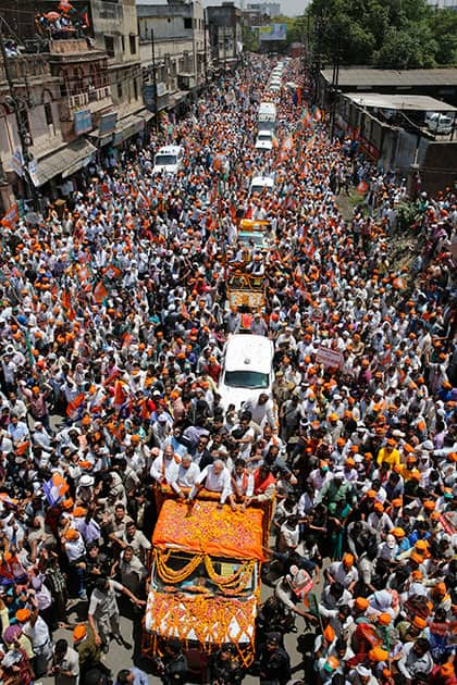 India`s main opposition Bharatiya Janata Party (BJP) `s prime ministerial candidate Narendra Modi, center, waves to supporters as he arrives in an open vehicle to file his nomination in Varanasi.